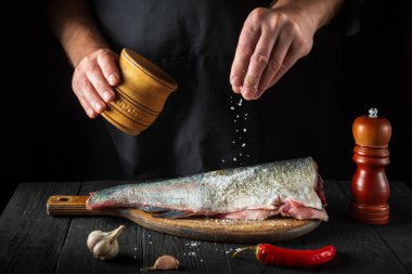 Profesyonel şef taze balık serpiştirir. Balık yemi pişirmeye hazırlanıyorum. Restoranın mutfağında çalışma ortamı