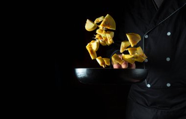 Şef kabağı tavaya koyuyor. Sebze pişirmek. Sağlıklı vejetaryen yemekleri ve yemekleri.