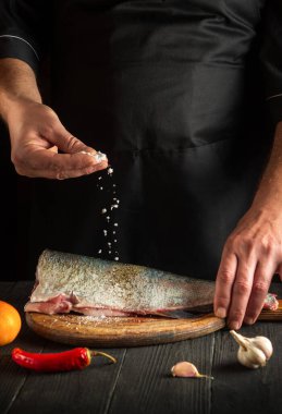 Profesyonel şef taze balık serpiştirir. Balık yemi pişirmeye hazırlanıyorum. Restoranın mutfağında çalışma ortamı