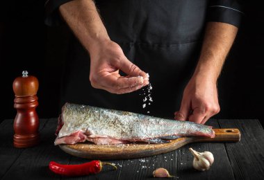 Profesyonel şef taze balık serpiştirir. Balık yemi pişirmeye hazırlanıyorum. Restoranın mutfağında çalışma ortamı