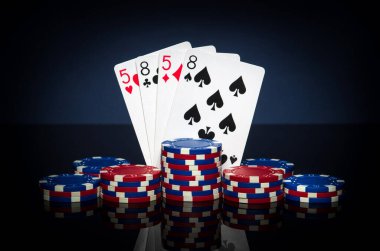 Pokerde iki çift kombinasyonlu kağıt oynamak. Fişler ve kartlar siyah masada. Başarılı ve kazançlı..