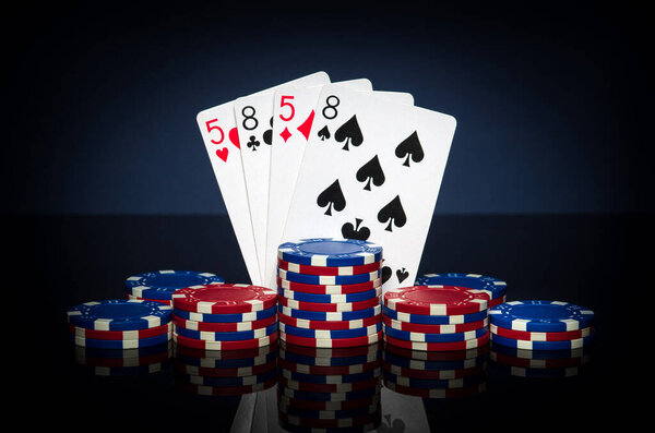 Playing cards in poker game with two pairs combination. Chips and cards on black table. Successful and win.