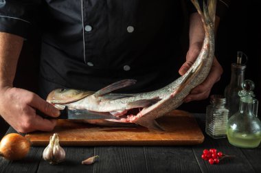 Şef gümüş sazan balığı hazırlıyor. Tatil için balık yemi hazırlamaya hazırlanıyorum. Restoranın mutfağında çalışma ortamı