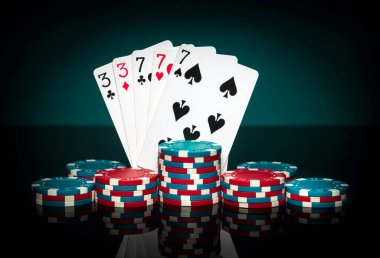 Fişler ve kartlar siyah masada. Pokerde, full house ya da full boat kombinasyonlu kâğıt oynamak. Başarılı ve kumarhanede kazanan.