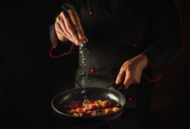 Kızarmış sebze pişirmek. Şef sıcak tavaya tuz ekliyor. Reklam alanı olan bir otel fikri. Asya mutfağı