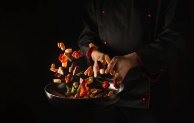 Şef kızartma tavasında taze sebzeler hazırlar. Sağlıklı vejetaryen yemekleri ve yemek tarifleri. Ücretsiz reklam alanı