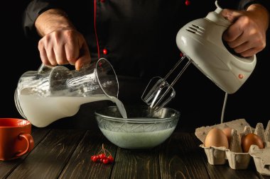 Profesyonel şef, mutfakta elektrikli el mikseri kullanarak süt ve yumurtalı lezzetli bir kahvaltı hazırlar. Aşçı, Poloko 'yu derin bir tabağa koyar. Otel için lezzetli tarif menüsü