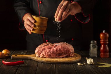 Şef çiğ ete tuz serper. Kızarmadan önce taze et hazırlıyorum. Restoran ya da otel menüsü konsepti. Asya mutfağı.