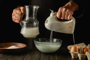 Şef lezzetli bir kahvaltı hazırlamak ya da yumurta ve sütle öğle yemeği hazırlamak için el yapımı bir elektrikli mikser kullanır. Restoran ya da otel için menü fikri.