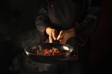 Mutfakta taze sebze pişiriyorum. Şef sıcak bir tavayı buharla tutuyor. Reklam alanı olan bir otel için Asya yemekleri fikri