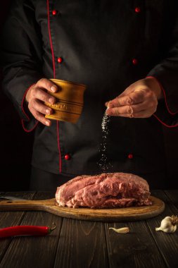 Şef çiğ ete tuz serper. Kızarmadan önce taze et hazırlıyorum. Restoran ya da otel menüsü konsepti. Avrupa mutfağı.