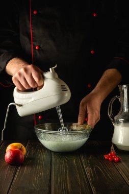 Şef meyve ve sütle lezzetli bir smoothie hazırlamak için el yapımı bir elektrikli mikser kullanır. Restoran ya da otel için menü fikri.