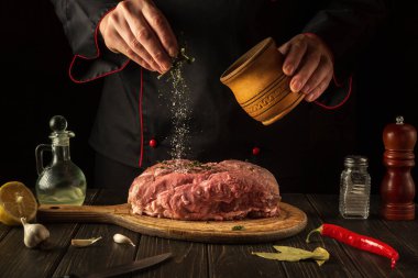 Ulusal bir yemek hazırlamadan önce çiğ ete lezzetli bir tat katmak. Mutfakta yemek pişirirken aşçı. Otel için menü kavramı