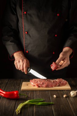 Şef barbeküden önce et dilimleme tahtasına çiğ et koyar. Asya mutfağı. Mutfakta lezzetli bir yemek hazırlıyorum..