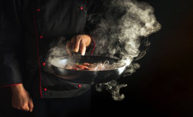 Profesyonel aşçı tavada sebze pişiriyor. Reklam yeri olan restoran ya da otel menüleri. Moleküler gastronomi ya da mutfak.