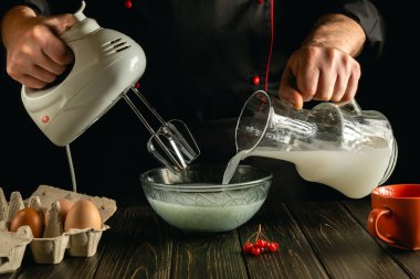 Aşçı, elektrikli el mikseri kullanarak mutfakta süt ve yumurtalı lezzetli bir kahvaltı hazırlar. Şef, Poloko 'yu derin bir tabağa koyuyor. Otel için lezzetli tarif menüsü