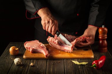 Kasap ızgaradan önce pirzola keser. Avrupa mutfağı. Otel için et yemeği fikri..