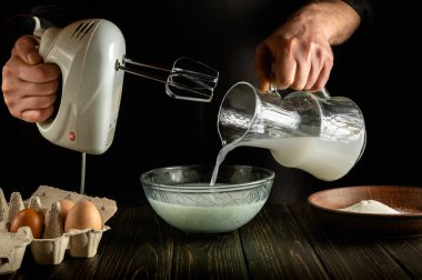 Profesyonel şef, elektrikli el mikseri kullanarak mutfakta süt ve yumurtalarla lezzetli bir akşam yemeği hazırlar. Aşçı, Poloko 'yu derin bir tabağa koyar. Otel için lezzetli tarif menüsü