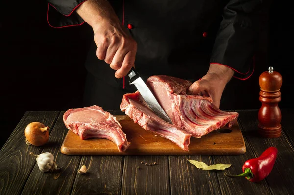 Bir kasap et yemeği hazırlamadan önce pirzola keser. Avrupa mutfağı. Otel Tarifi Fikri.