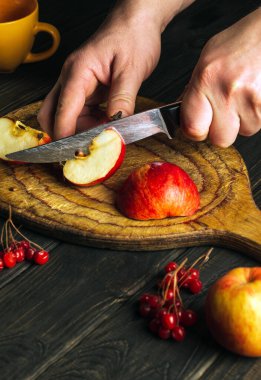 Profesyonel aşçı komposto ya da meyve suyu yapmak için kesme tahtasıyla elma keser. Mutfak masasında çalışma ortamı