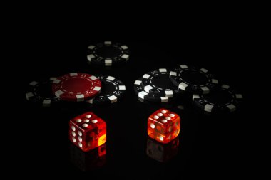 Siyah bir masada poker zarları ve arka planda çipler. Reklam için boş alan.