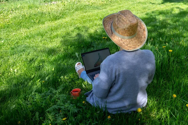 自然の中で屋外でフリーランス 庭ではノートパソコンを持った女性が働いている バックビュー — ストック写真