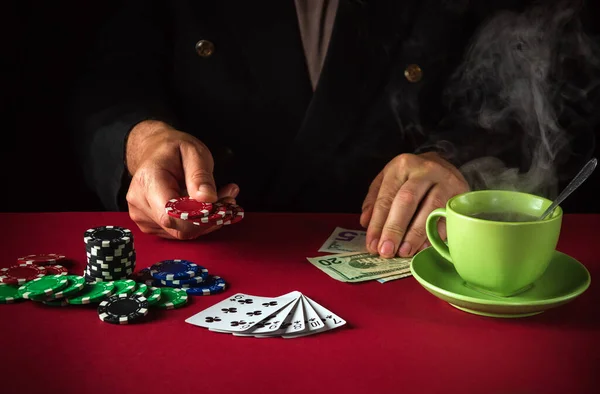 Lucky win in a poker club game. The player places a bet with chips on playing cards with a winning straight flush combination