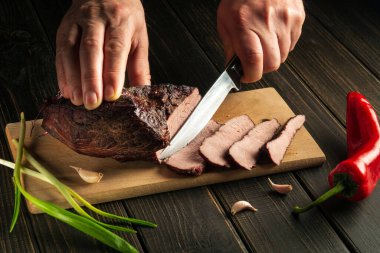 Aşçı soğuk meze ya da akşam yemeği için fırında eti keser.