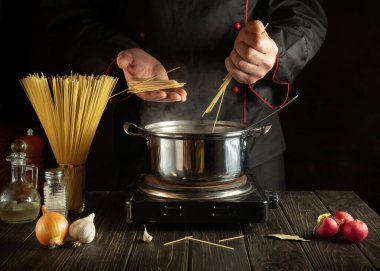 Şef İtalyan makarnası hazırlıyor. Aşçı mutfakta spagetti tutuyor. Avrupa mutfağı