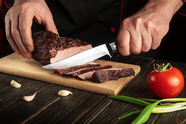 Şef dana etini kesme tahtasıyla keser. Lezzetli yemekler pişirme kavramı