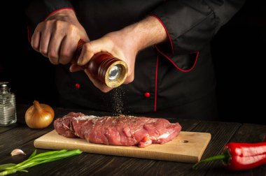 Profesyonel şef dana eti hazırlar ve biber ya da kırmızı biber ekler. Barbekü sırasında mutfakta çalışma ortamı