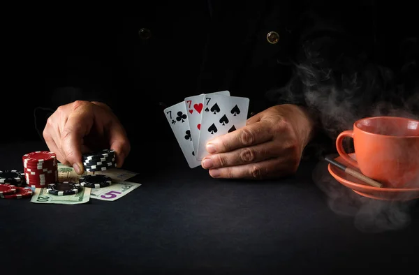 The player shows cards with a winning combination of three of a kind or set in a poker club. Luck or fortune in the casino