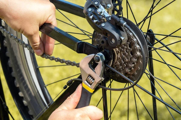 The idea of an urgent departure of a bicycle repair mechanic to the scene of an accident. Hands of the master close-up with a key during the repair of a bike.