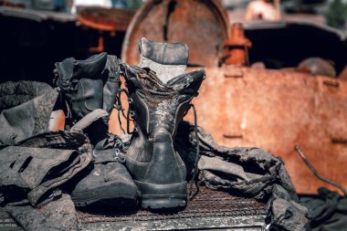 Fragments of burnt boots and clothes of a Russian soldier on a wrecked armored vehicle in the war in Ukraine