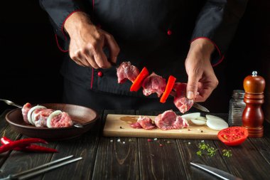 The chef prepares a delicious shish kebab with raw lamb in the kitchen. Asian cuisine.