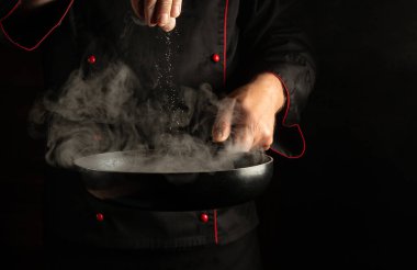 Aşçı sıcak bir tavadaki et bifteğine buharlı tuz ekler. Hamburger için köfte pişiriyorum.