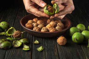 Aşçı mutfakta kullanmak için mutfak masasındaki fındıkları temizler. Bir fıstıkla şefin ellerinin yakın çekimi..