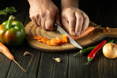 Şef vejetaryen öğle yemeği ya da kahvaltı hazırlamak için havucu kesme tahtasına koyar. Lezzetli sağlıklı yemek..