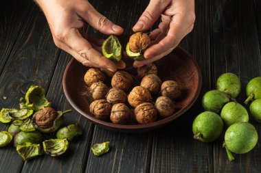 Bir hasattan sonra bir aşçının elleriyle yeşil deriden fındık temizlemek. Mutfak masasında çalışma ortamı