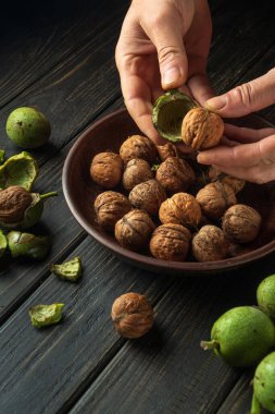 Bir hasattan sonra bir aşçının elleriyle yeşil deriden fındık temizlemek. Mutfak masasında çalışma ortamı.