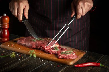 Şef pişirmeden ya da barbeküden önce panoda çiğ et hazırlıyor. Restoran ya da otel tarifi.