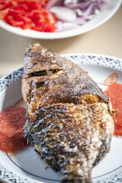 Tilapia cuit au four servi avec sauce au poivron rouge — Photo