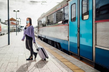 Genç kadınlar trenden indiler, platformda duruyorlar, maceraya hazırlar, Portekiz