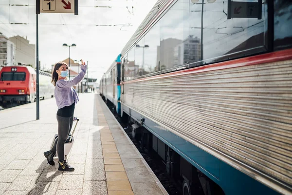 Tren istasyonunda trenle ayrılan birine el sallıyor ve veda ediyordu.