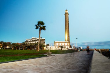 Lighthouse on rocky coast during sunset in Maspalomas, Gran Canaria, Spain