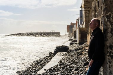 A man relaxing by the Atlantic Ocean during sunny day, Pozo Izquierdo, Gran Canaria, Spain
