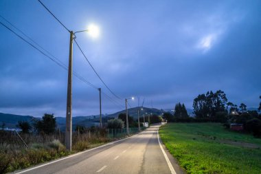 Illuminated old, rural road in the cloudy evening, Torres Vedras, Portugal