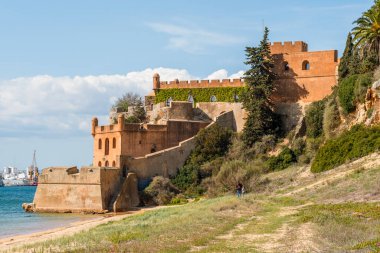 Kumlu sahil şeridi ve Ferragudo, Algarve, Portekiz 'deki Sao Joao kalesi.
