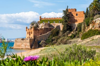 Kumlu sahil şeridi ve Ferragudo, Algarve, Portekiz 'deki Sao Joao kalesi.