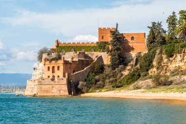 Kumlu sahil şeridi ve Ferragudo, Algarve, Portekiz 'deki Sao Joao kalesi.
